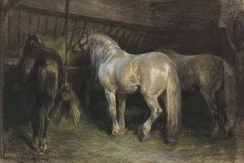 Caballos comiendo heno en un establo