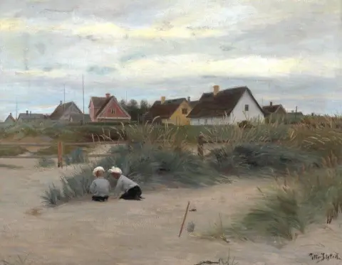 Barn Leker På Stranden I Bakgrunden En Rad Av Hus